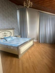 a bedroom with a bed with blue sheets and wooden floors at Buzovna Villa in Baku +5 photos