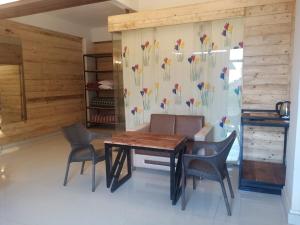 a dining room with a wooden table and chairs at Pinewood mahabaleshwer in Panchgani