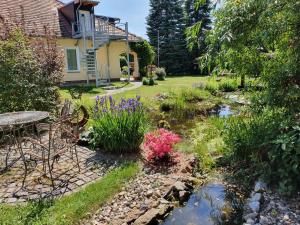 a garden with a pond and a table and chairs at Gästehaus am schmalen See UG haftungsbeschränkt in Lauchhammer
