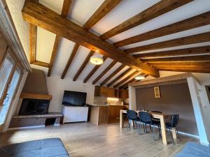 a kitchen and dining room with wooden ceilings and a table and chairs at Appartamento chalet in Laax