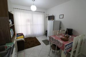 eine kleine Küche mit Tisch und Kühlschrank in der Unterkunft Apartamento Penha in Penha