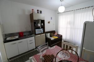 eine kleine Küche und ein Wohnzimmer mit einem Tisch in der Unterkunft Apartamento Penha in Penha