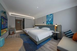 una habitación de hotel con dos camas y un sofá en Echarm Hotel Potala Palace Da Zhao Temple Branch, en Lhasa