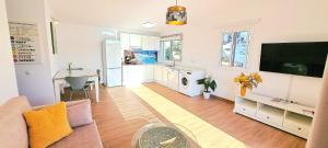 a living room with a couch and a tv at Apartamento Onix Jacuzzi in Tarajalejo +3 photos