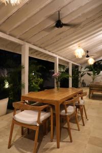 Una mesa y sillas de madera en un patio. en Villa Tom & Lucie Bingin Beach, en Uluwatu 16 fotos más