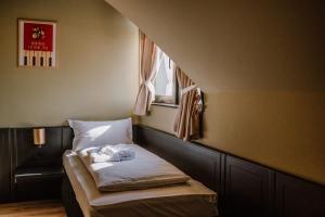 a small bed in a room with a window at Motel Oasis in Corunca +54 photos