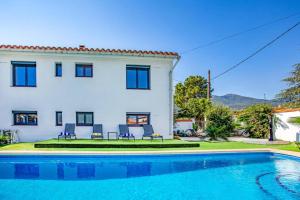 a villa with a swimming pool in front of a house at Villa du Soleil by Villa Plus in Laroque-des-Albères