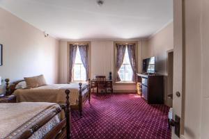 a hotel room with two beds and a television at Oneida Community Mansion House in Oneida