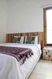 Un dormitorio con una cama grande con sábanas blancas. en Villa Tom & Lucie Bingin Beach, en Uluwatu