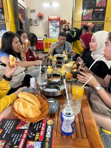 eine Gruppe von Menschen sitzt um einen Tisch herum und isst in der Unterkunft CoCo home 15 in Ho-Chi-Minh-Stadt