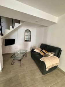 a living room with a black couch and a glass table at La Maison de Sainte-Eulalie in Roubia