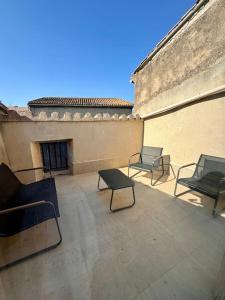 a patio with chairs and tables on a building at La Maison de Sainte-Eulalie in Roubia
