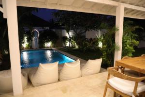 Una piscina en un patio trasero por la noche. en Villa Tom & Lucie Bingin Beach, en Uluwatu