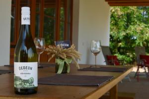 a bottle of wine sitting on top of a wooden table at Kövidinka Vendégház in Izsák
