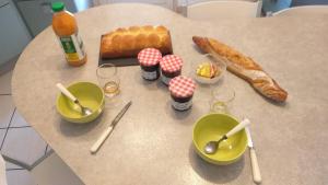a table with some food and some bowls and spoons at chambre avec petit-déjeuner #1 in Aurillac