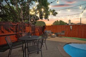 een terras met een tafel en stoelen naast een zwembad bij Modern Comforts & Classic Charm w Pool 5BD in Saginaw