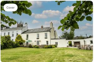 ein großes weißes Haus mit einem großen Garten in der Unterkunft The old Manor House in Lifton