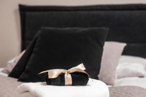 a black and gold bow on top of a bed at Santa's Luxury City Apartment 1 in Rovaniemi