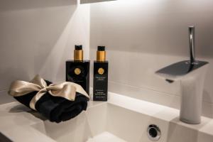 two bottles of perfume on a white counter with a sink at Santa's Luxury City Apartment 1 in Rovaniemi