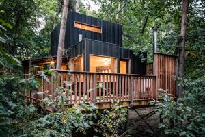 ein Haus im Wald mit einer Holzterrasse in der Unterkunft Bosuil in Retie + 5 Fotos
