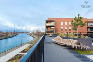 a walkway with benches next to a river at City Center - Amber Sky Apartments by Apartmore in Gdańsk