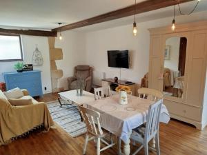 a living room with a table with chairs and a couch at Gite Le petit moineau in Corgnac-sur-lʼIsle
