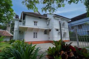 una casa bianca con una recinzione e alcune piante di Govindamangalam Homestay a Cochin