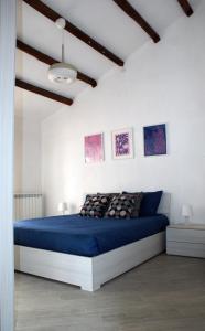 a bedroom with a blue bed in a white room at Marcondirondirondello in Tivoli