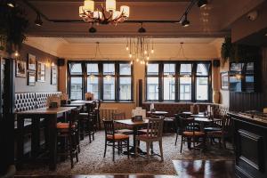 a dining room with tables and chairs and windows at The Dukeries Lodge, Edwinstowe, Nottinghamshire in Edwinstowe