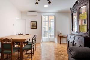 a dining room with a wooden table and chairs at Vultus - CatedralHomes in Ávila