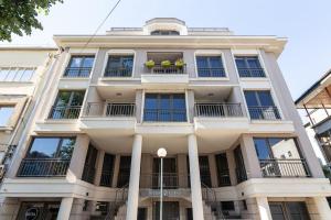 a white building with windows and balconies at Peaceful retreat - free parking in Plovdiv