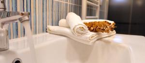 a white bathroom sink with towels and a faucet at Marcondirondirondello in Tivoli +11 photos