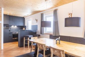 kuchnia i jadalnia z drewnianym stołem w obiekcie Alpendorf Dachstein West by ALPS RESORTS w mieście Annaberg im Lammertal