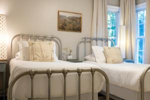 琼斯伯勒Sink into the Luxe Corner Tub at an Upscale, Spacious Home的卧室内的两张床,配有白色床单和枕头