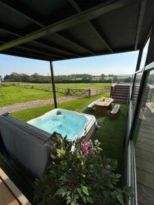 BonvilstonにあるLuxury Lake Front Escape With Hot Tubの家のパティオにあるホットタブ