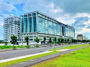 a large glass building on the side of a road at Sutera Avenue Kota Kinabalu City Centre LW Suites in Kota Kinabalu