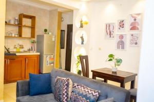 a living room with a couch and a kitchen at Résidence cosy or in Douala