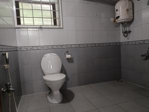 bagno con servizi igienici bianchi e finestra di Trilan Cottages - Donnington Road a Kotagiri