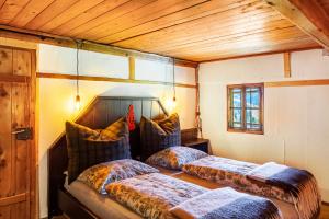 two beds in a room with wooden ceilings at Kastnhäusl Wildschönau Urige Hütte in Oberau