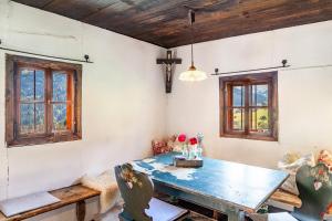 a dining room with a table and two windows at Kastnhäusl Wildschönau Urige Hütte in Oberau +21 photos