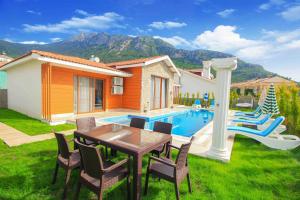 a backyard with a table and chairs and a pool at Tlos Deluxe 3+1 Villa ,Özel Havuzlu, Fethiye in Fethiye
