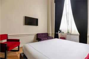 a hotel room with a bed and two chairs at Roma Luxus Hotel in Rome