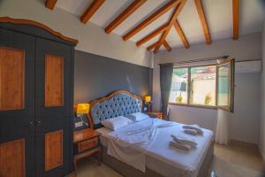 a bedroom with a bed and a window at Tlos Deluxe 3+1 Villa ,Özel Havuzlu, Fethiye in Fethiye +9 photos