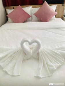 two swans forming a heart on a bed at Sunshine guesthouse in Ban Saiyuan (1)