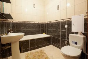 a bathroom with a toilet and a sink and a bath tub at Апартаменти на Сихові 3й in Lviv