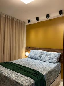 a bedroom with a bed and a yellow wall at Sonhos da Serra Bananeiras - O melhor apartamento de bananeiras in Bananeiras