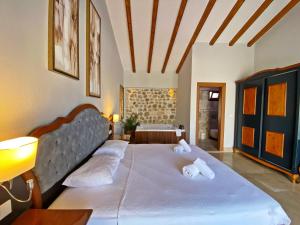 ein Schlafzimmer mit einem großen Bett mit zwei Kissen in der Unterkunft Tlos Dream 3+1 Villa, Özel Havuzlu, Fethiye in Fethiye