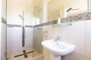 a white bathroom with a shower and a sink at Villa Blue Sky Cape Town in Cape Town +21 photos