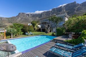 a house with a swimming pool with mountains in the background at Villa Blue Sky Cape Town in Cape Town