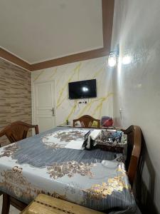 タンジェにあるAppart à 150m de la plage, 5 min City Mall et TGVのベッドと壁にテレビが掛かった寝室